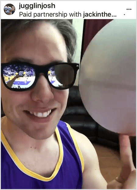 Josh Horton legger ut et bilde for en kampanje med Jack in the Box og LA Lakers. Josh bruker speilende solbriller og en Lakers-trøye og smiler for kameraet mens han snurrer en ball.